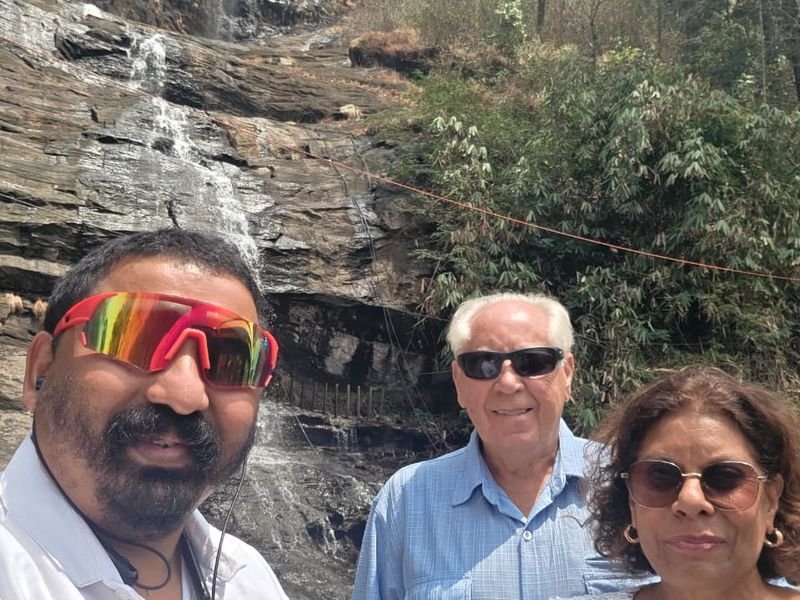 Driver Antony posing with foreign tourists near waterfalls 8