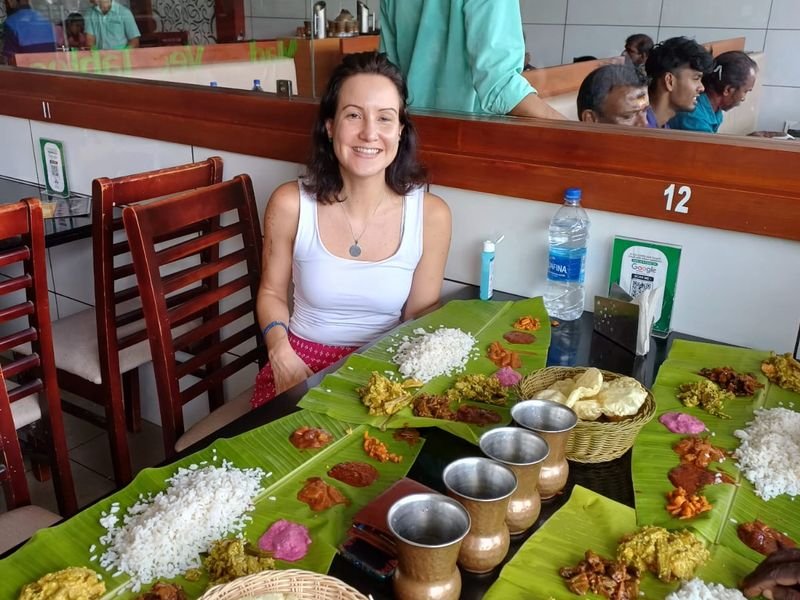 Foreign Tourist posing for a photo with Kerala traditional style lunch in banana leaf