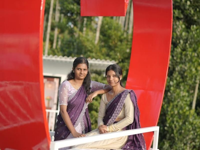 Travelers posing for photo inside a heart